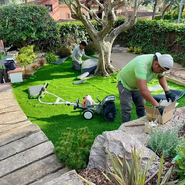 Un hombre con una camisa verde está trabajando en un jardín.