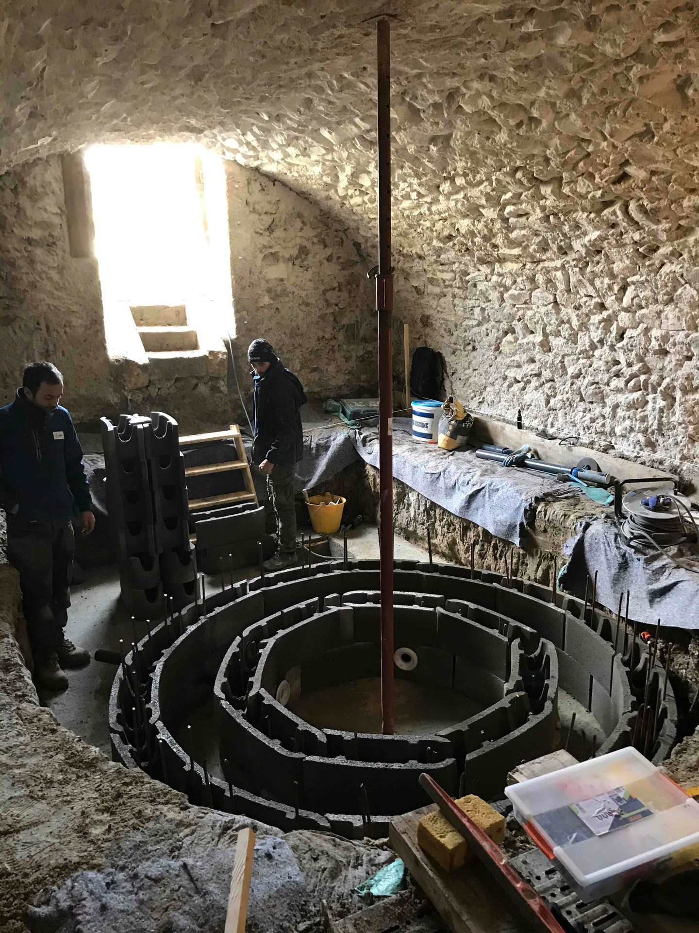 Ouvrier dans une salle voutée en pierre réalisant un sous bassement pour la création d'un spa