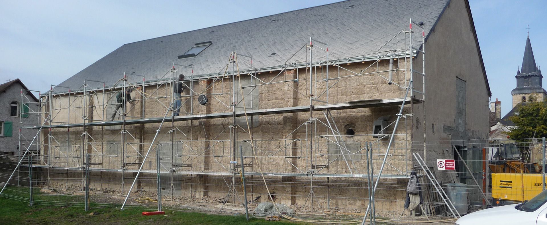 Façade de grange échafaudée en cours de réfection