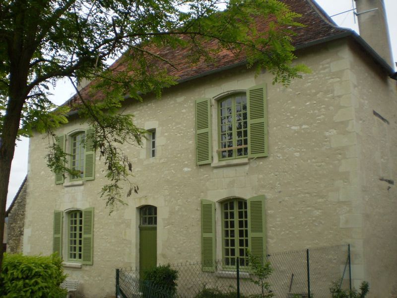 Maison charmante avec volet vert clair et façade en pierre