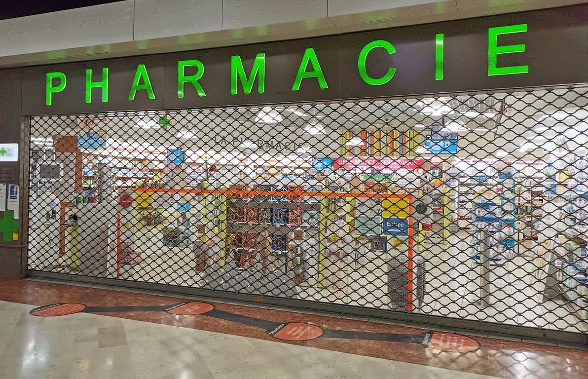 Rideau métallique baissé protégeant une pharmacie.