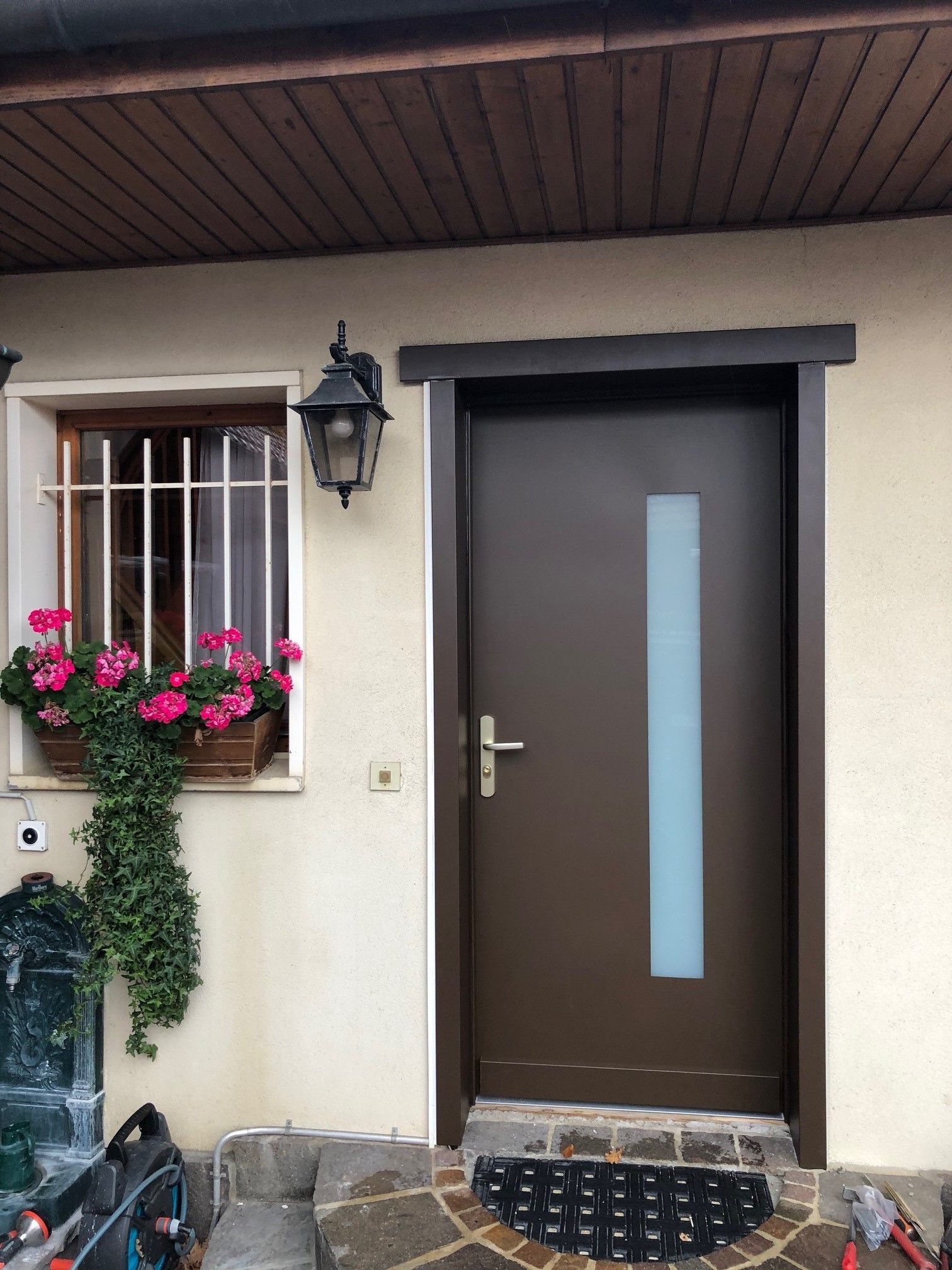 Porte blindée en bois avec une partie vitrée verticale.