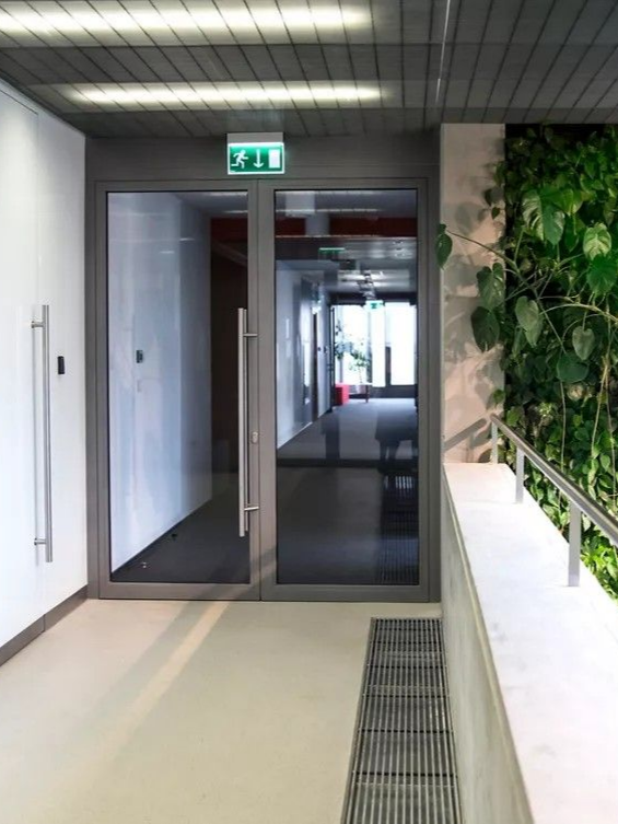 Porte de hall avec indication de sortie de secours au-dessus.