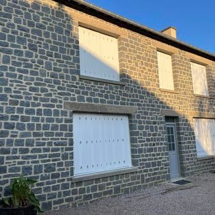 Une maison avec des volets blancs