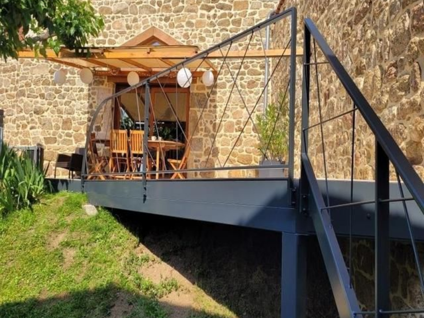 Vue extérieure d'un bâtiment avec une terrasse et des escaliers.