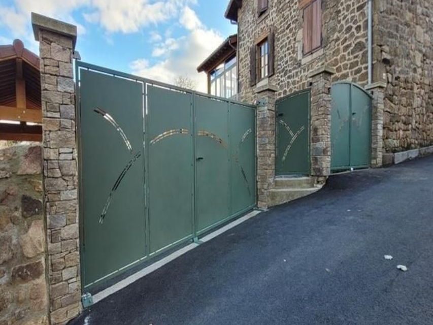 Portail d'allée en métal vert avec découpes décoratives.