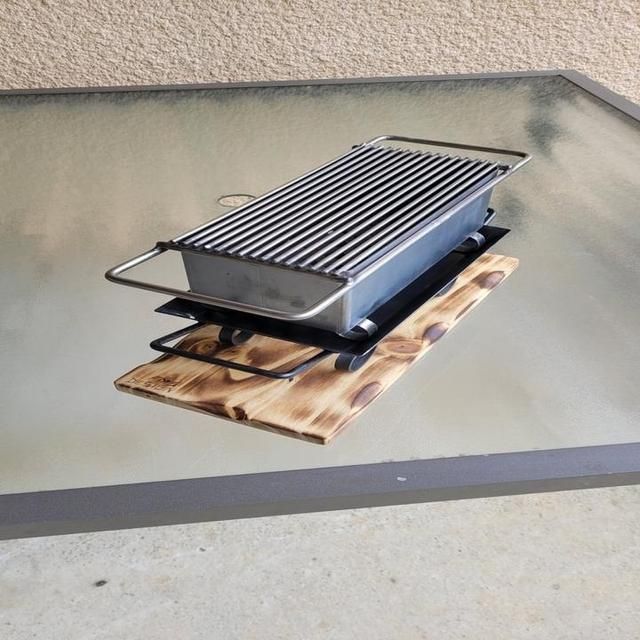 Un gril portable reposant sur une base en bois.