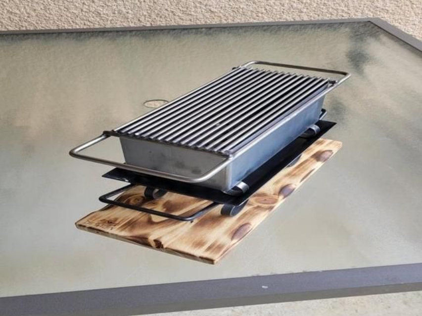 Petit barbecue portable avec une base en bois.