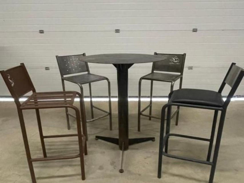 Quatre tabourets de bar en métal entourant une table ronde devant une porte de garage.