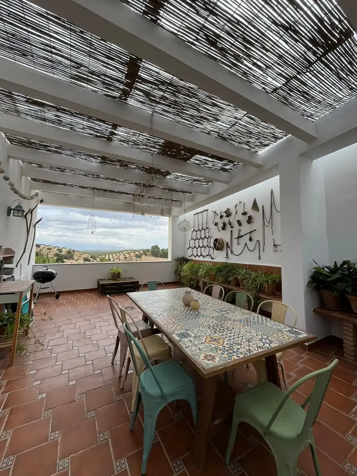 Un patio con una mesa y sillas bajo un dosel.