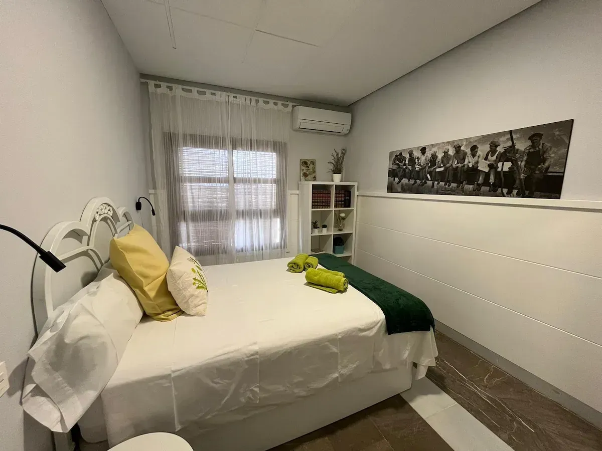 Un dormitorio con una cama grande y un cuadro en la pared.
