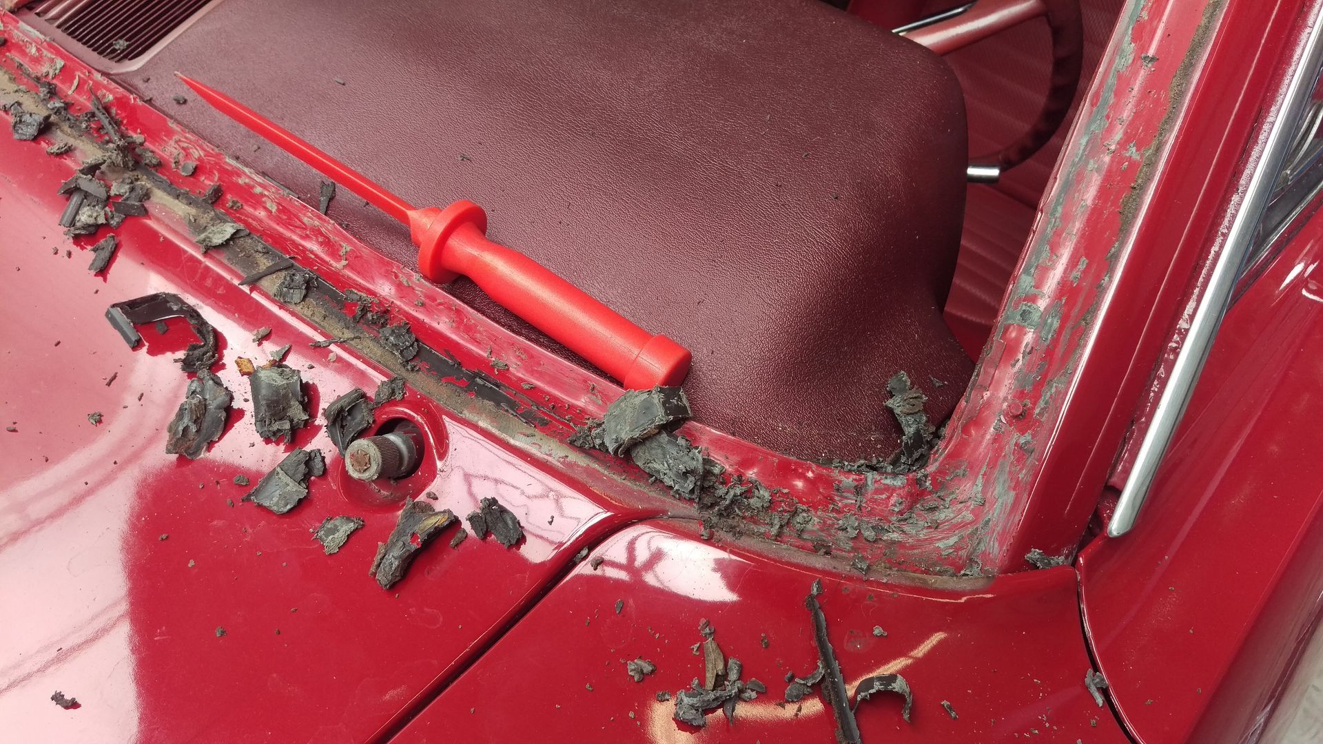 Ein rotes Auto mit einem roten Schraubendreher auf der Windschutzscheibe