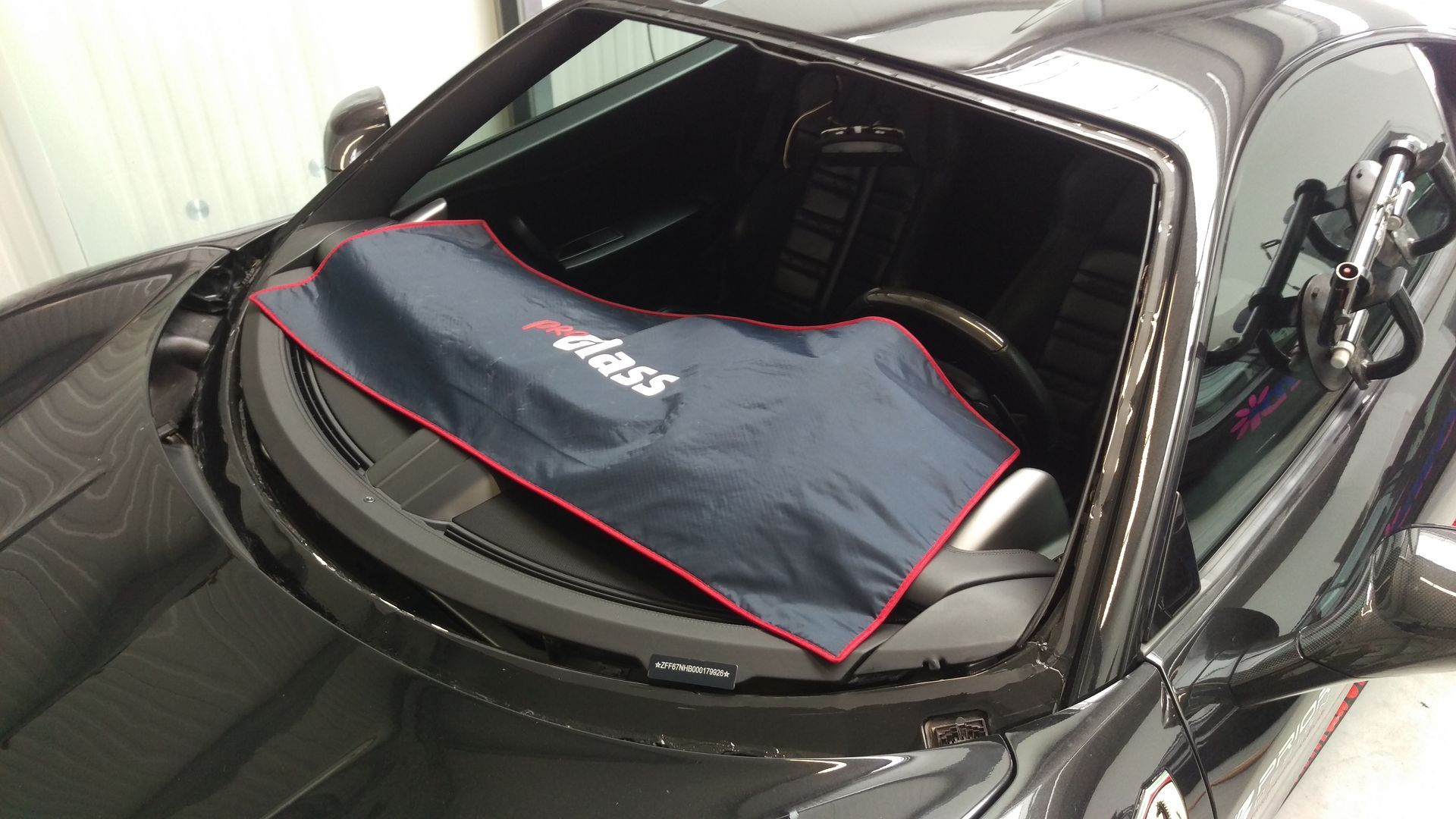 Ein schwarzes Auto mit einem blauen Tuch auf der Windschutzscheibe