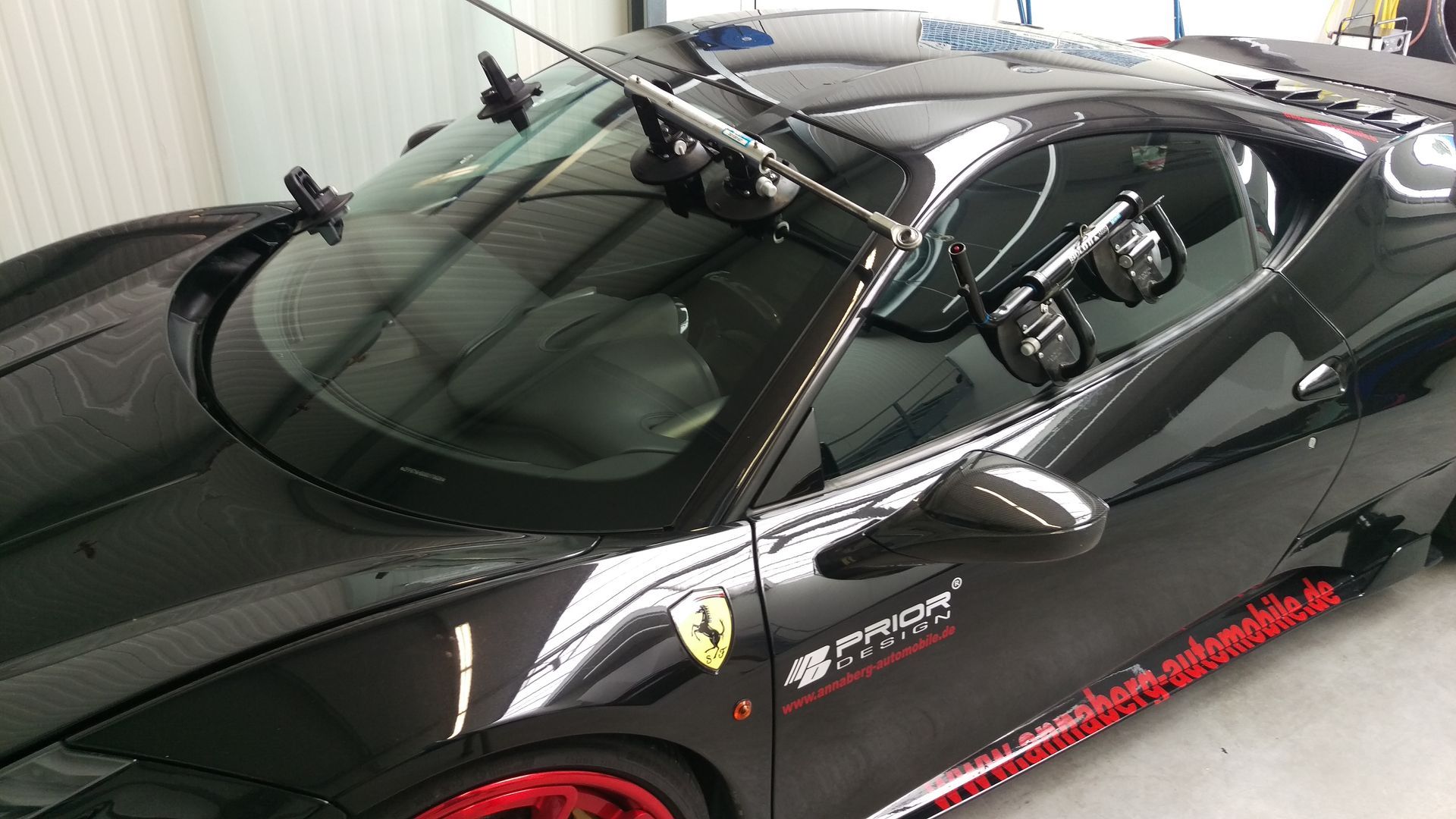 Ein schwarzer Ferrari-Sportwagen steht in einer Garage.