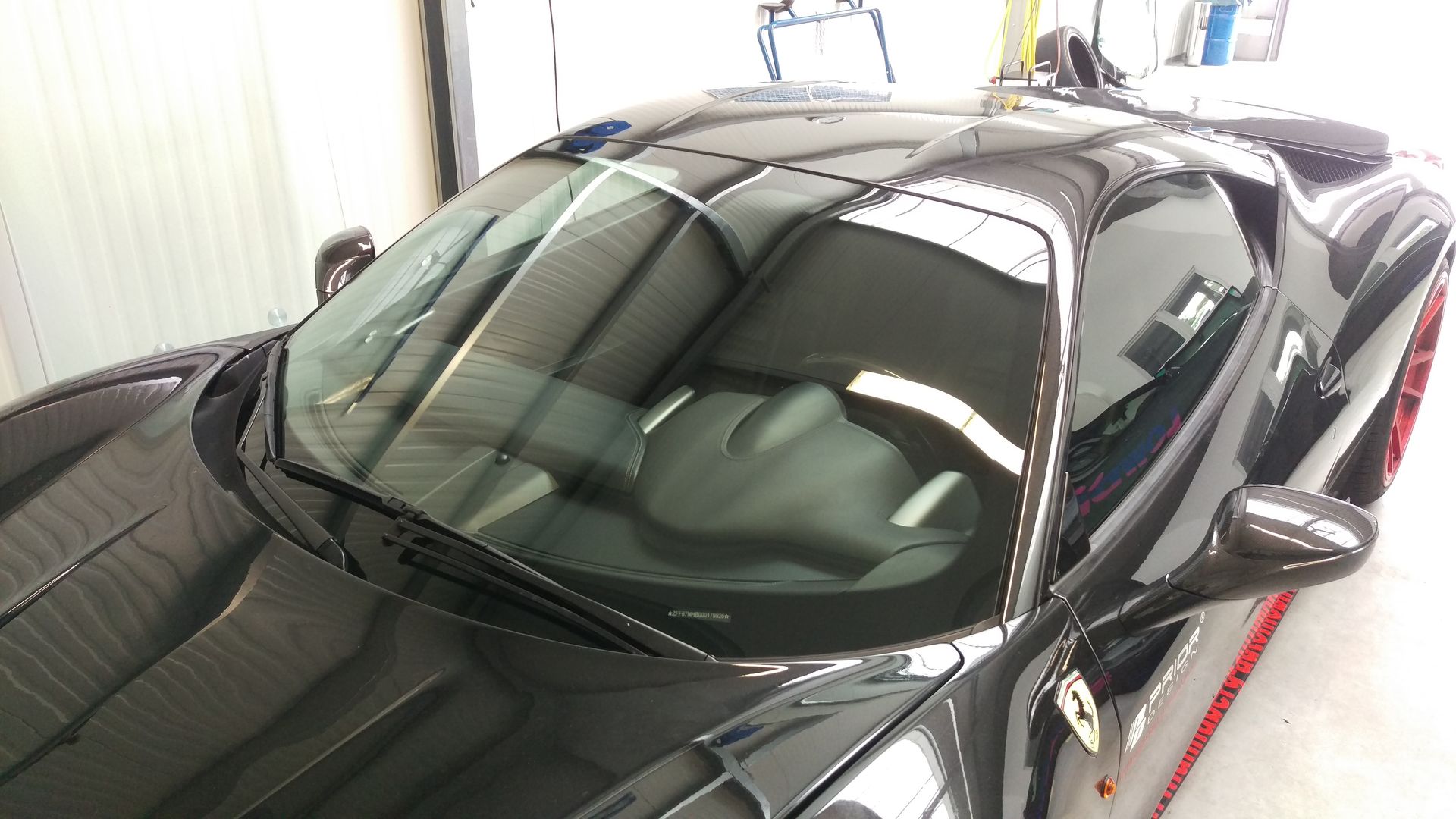 Ein schwarzer Sportwagen steht in einer Garage.