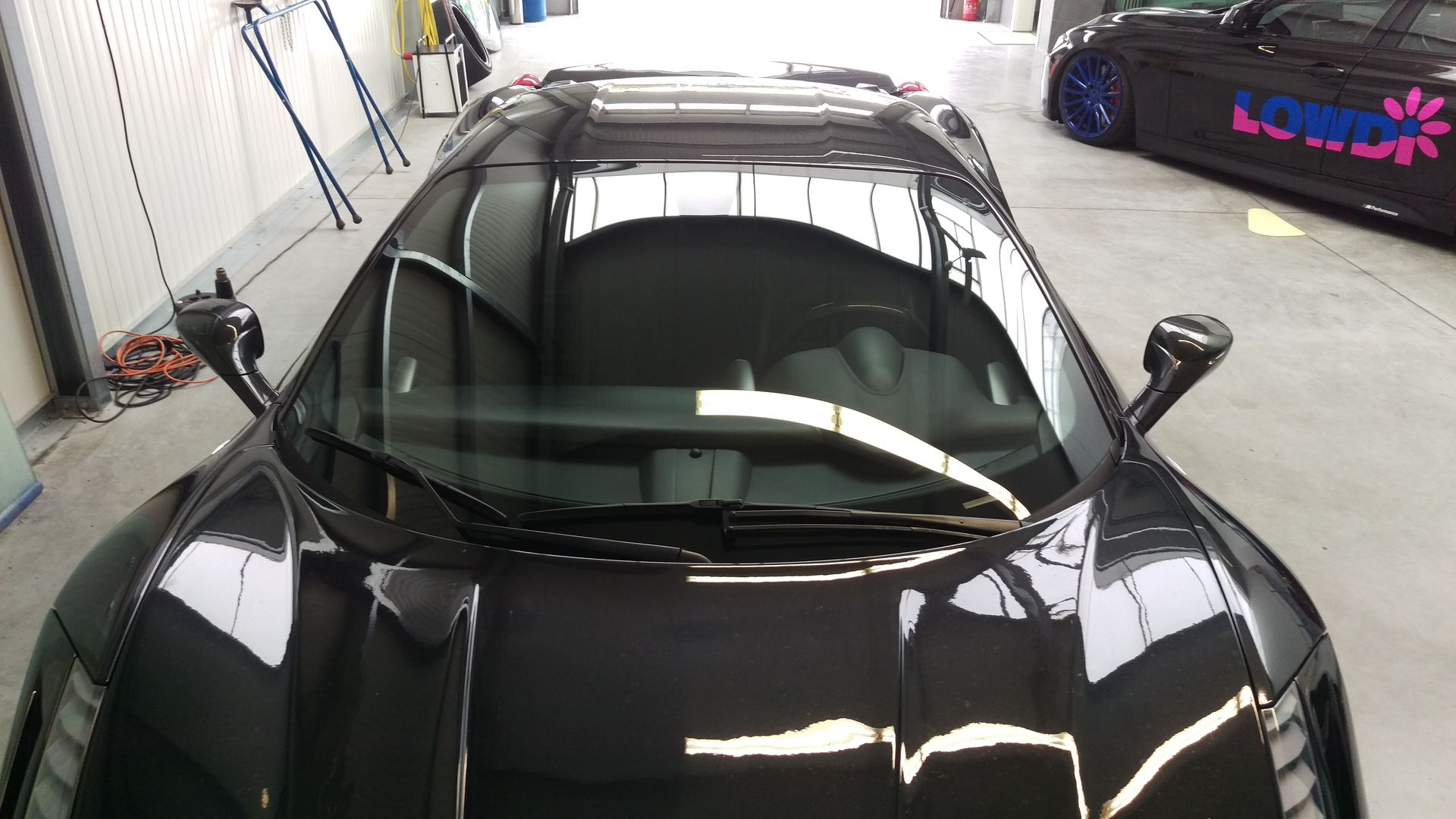 Ein schwarzer Sportwagen steht in einer Garage.