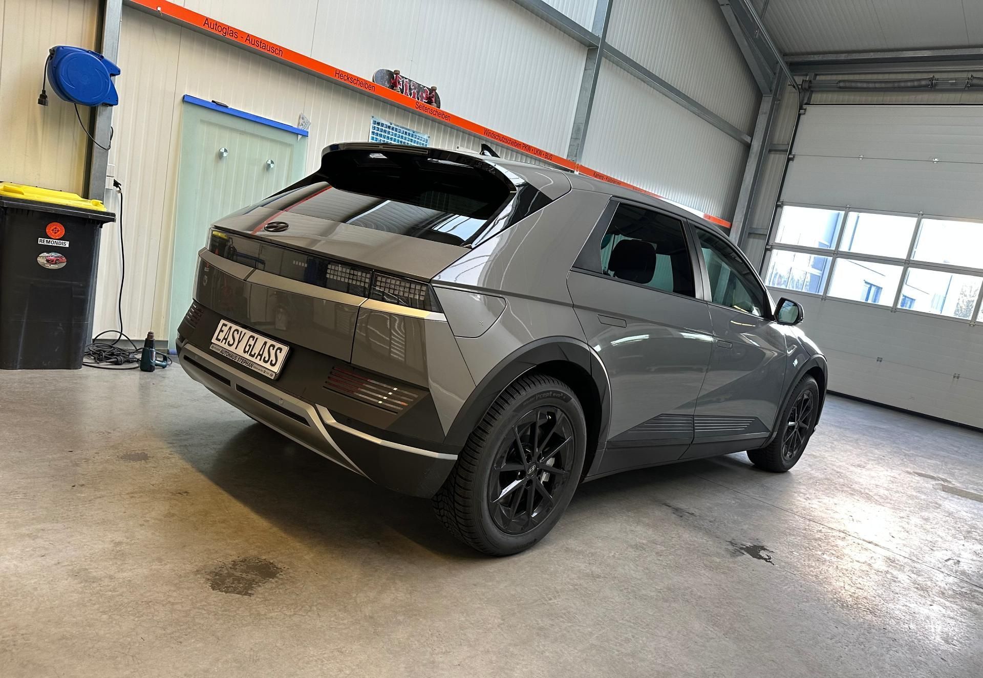 ein graues Auto mit der Aufschrift easy glass in einer Garage