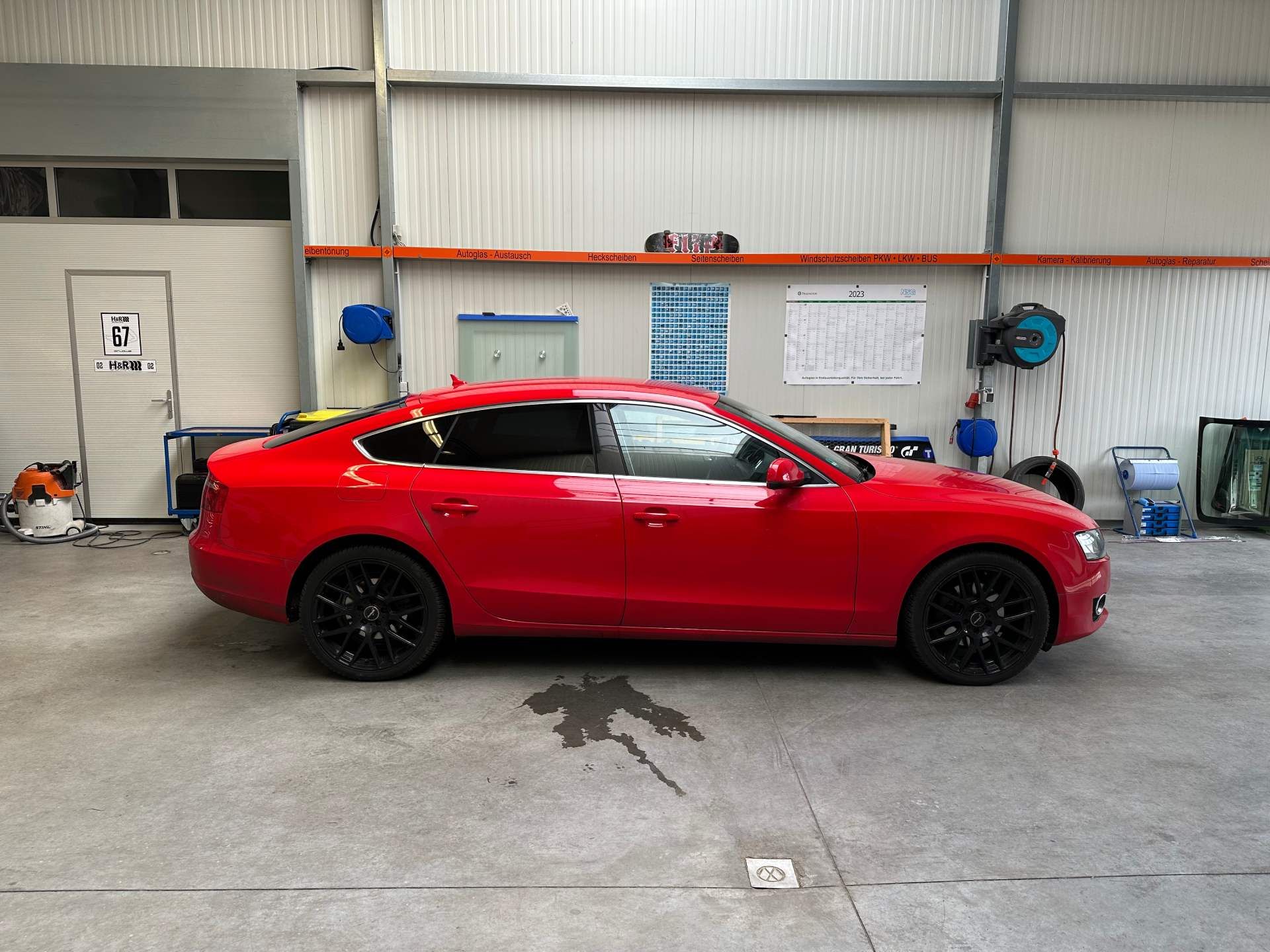 Ein rotes Auto steht in einer Garage.