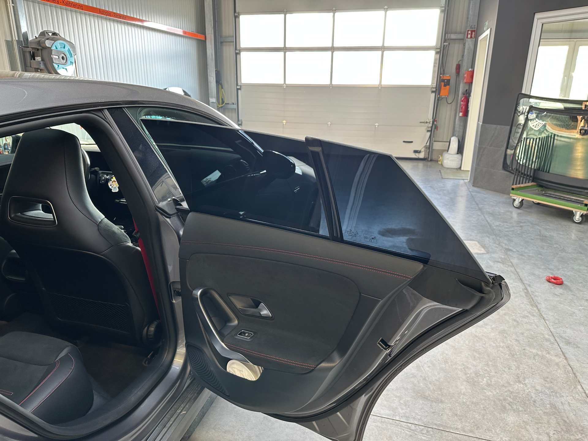 Die hintere Tür eines Autos in einer Garage ist offen.