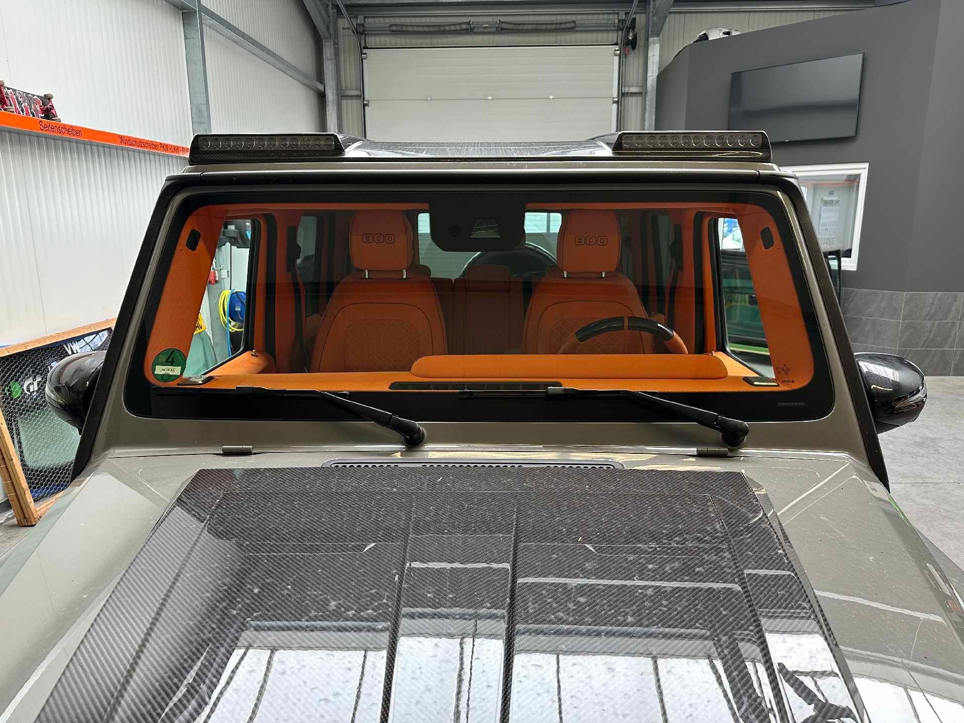 Ein Jeep ist in einer Garage mit einem Dachfenster geparkt.