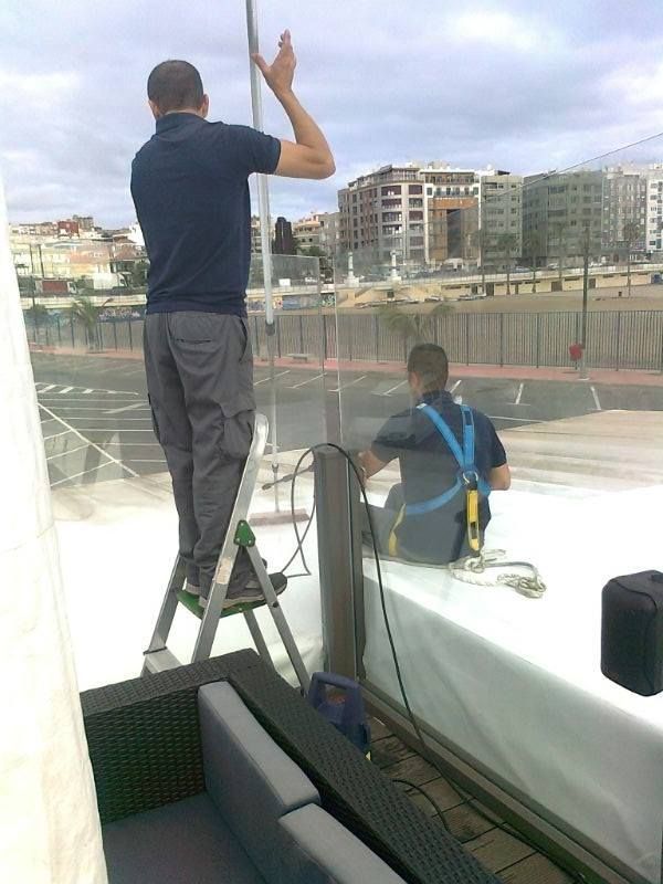 Un hombre está de pie en una escalera mientras otro hombre está sentado en un sofá.