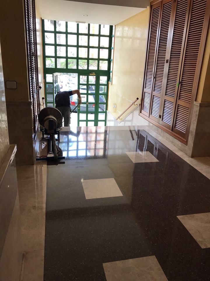 Un hombre está parado en un pasillo frente a una puerta verde.