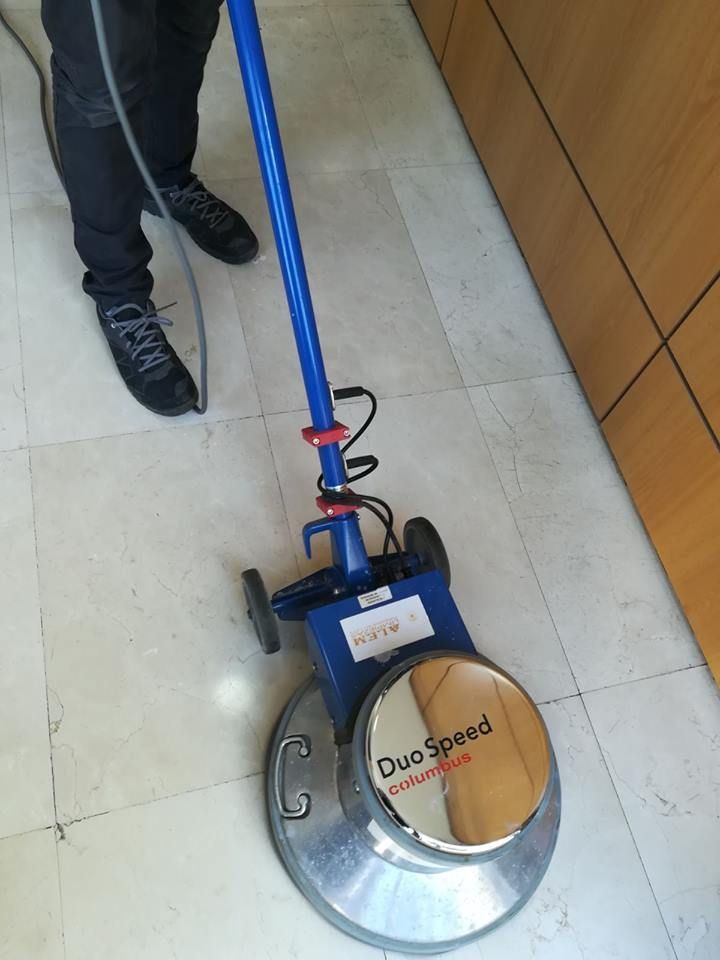 Una persona está usando una aspiradora en un piso de baldosas.