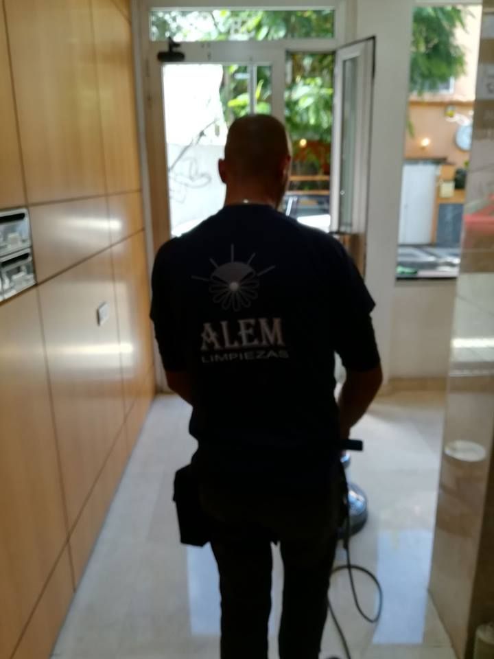 Un hombre que lleva una camisa negra camina por un pasillo.