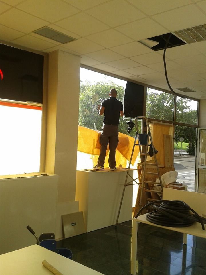 Un hombre está de pie en una escalera frente a una ventana grande.