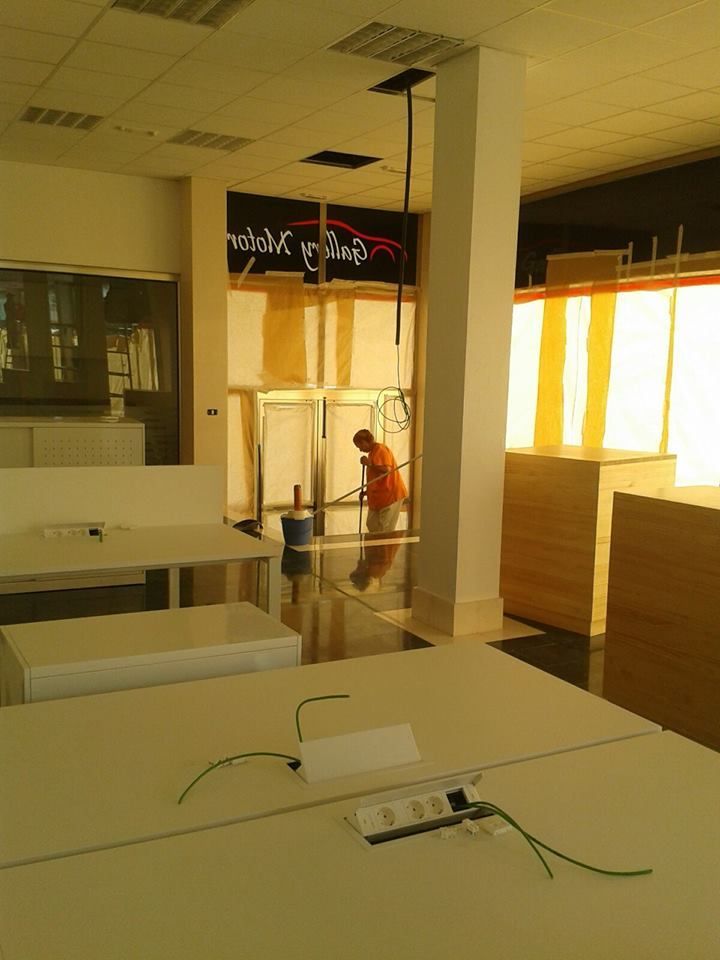 Un hombre está limpiando el suelo de una habitación con un cartel que dice 'nirvana'.