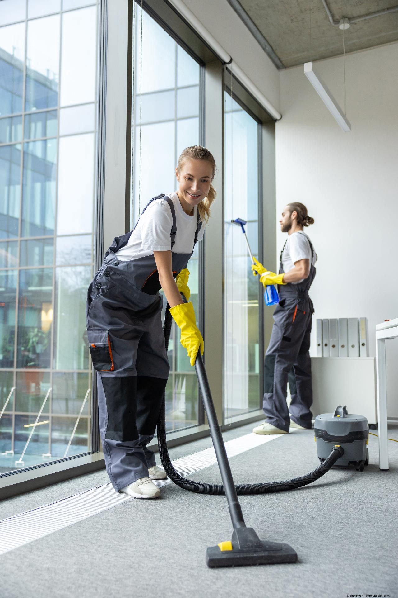 Reinigungskraft arbeitet in modernem Gebäude