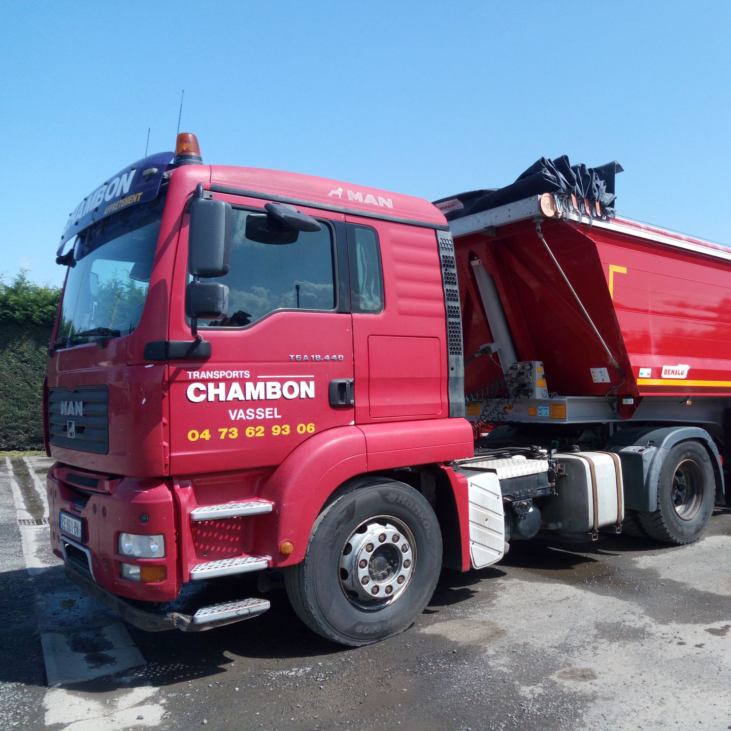 Camion CHAMBON rouge stationné à l'extérieur par une journée ensoleillée.