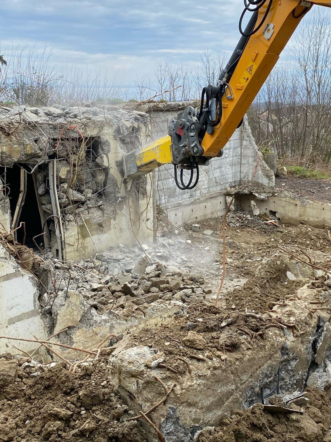 Mur en train d'être cassé avec une machine.