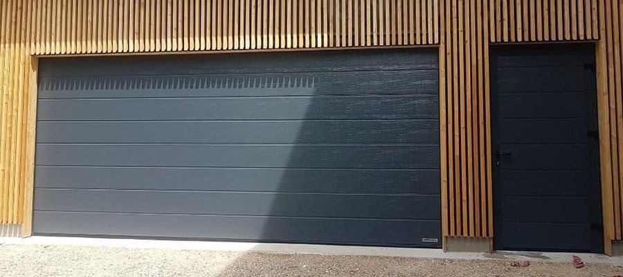 Porte de garage installée sur une maison en bois