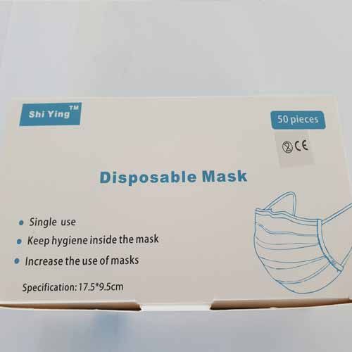 Auf einem Tisch steht eine Schachtel mit Einwegmasken.