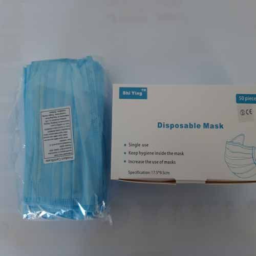 Eine Schachtel mit Einwegmasken steht neben einer Tüte mit Einwegmasken.