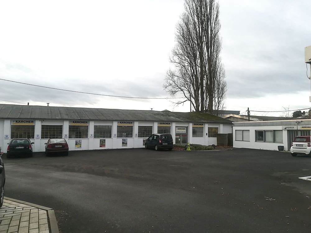 Ein Parkplatz mit vor einem Gebäude geparkten Autos