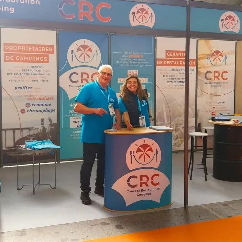 Un monsieur et une madame derrière un comptoir sur le stand CRC
