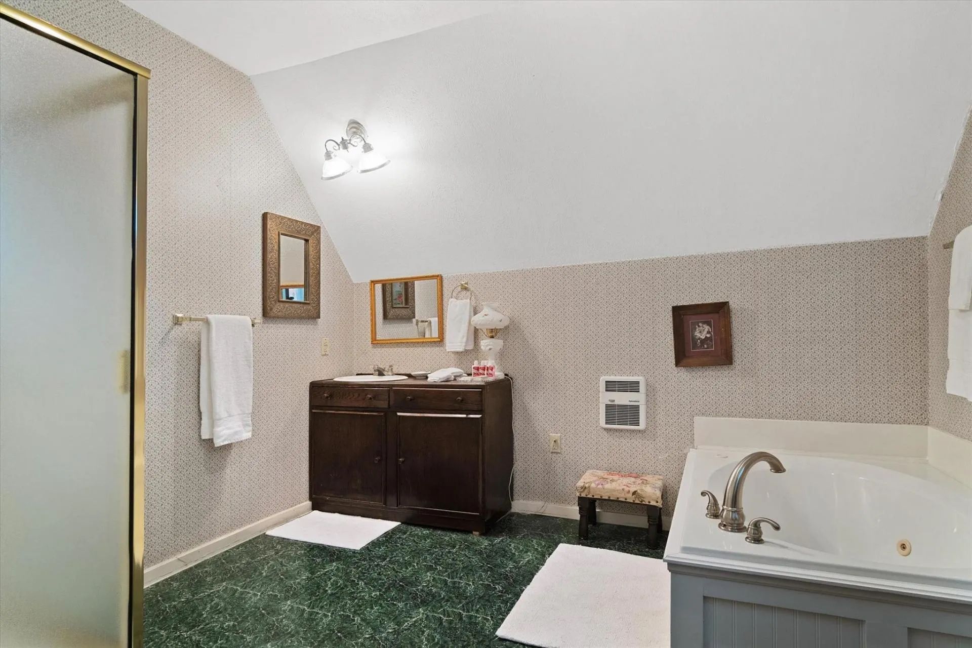 A bathroom with a jacuzzi tub , sink and mirror.