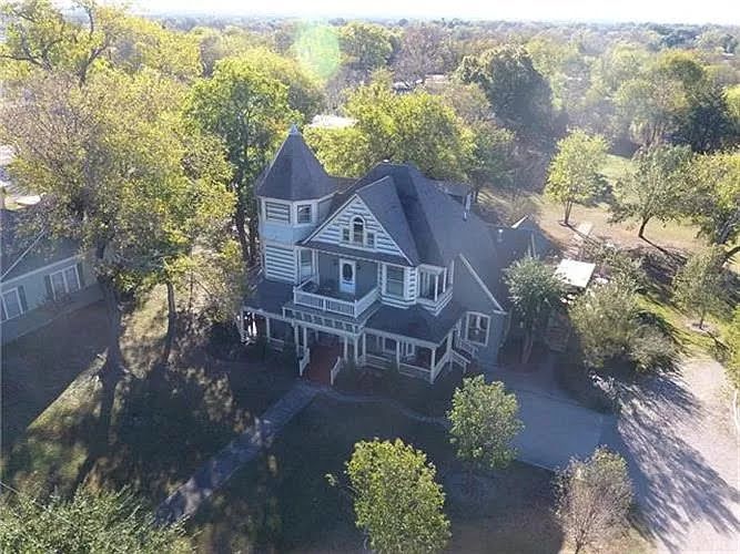 An aerial view of a large house surrounded by trees.