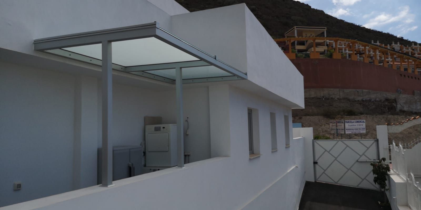 Un edificio blanco con una marquesina de vidrio encima.