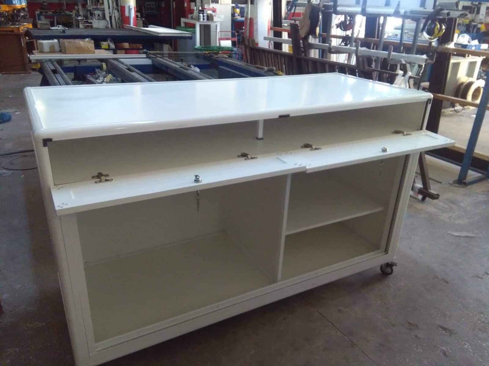 Un armario blanco con puertas corredizas está sobre un piso de concreto.