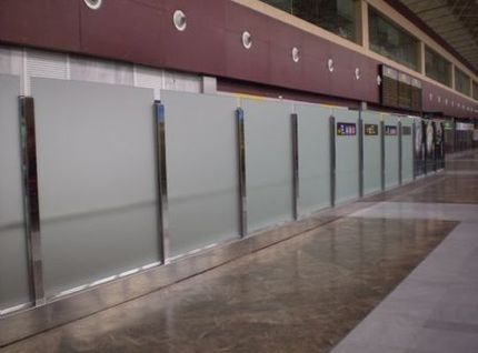 Una hilera de paredes de vidrio esmerilado en una terminal de aeropuerto.