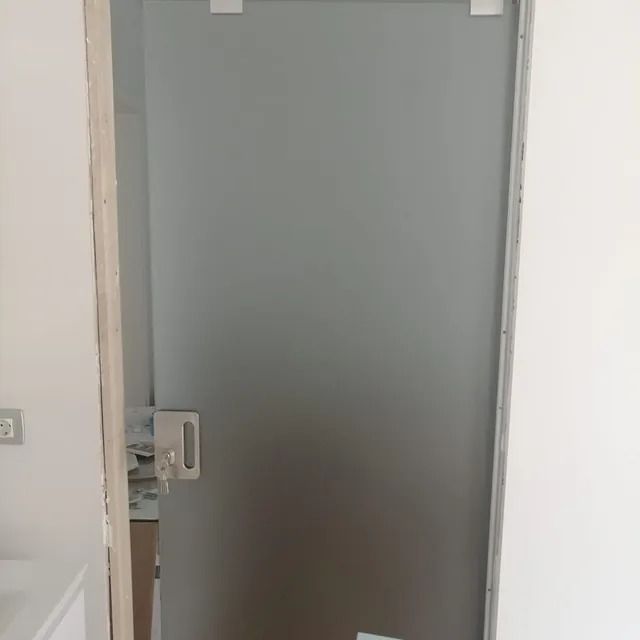 Un baño con puerta de cristal y lavabo.