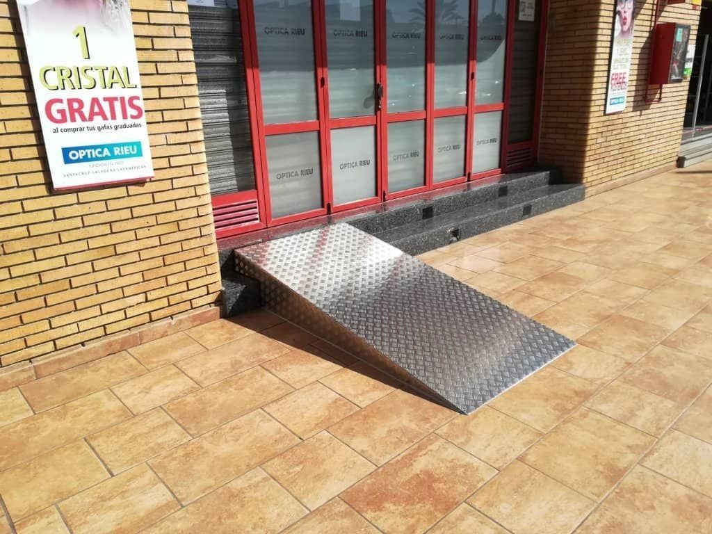 Una rampa de metal se encuentra frente a un edificio de ladrillos.