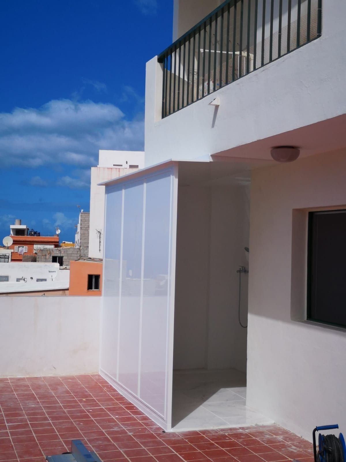 Un edificio blanco con un balcón y una ventana.