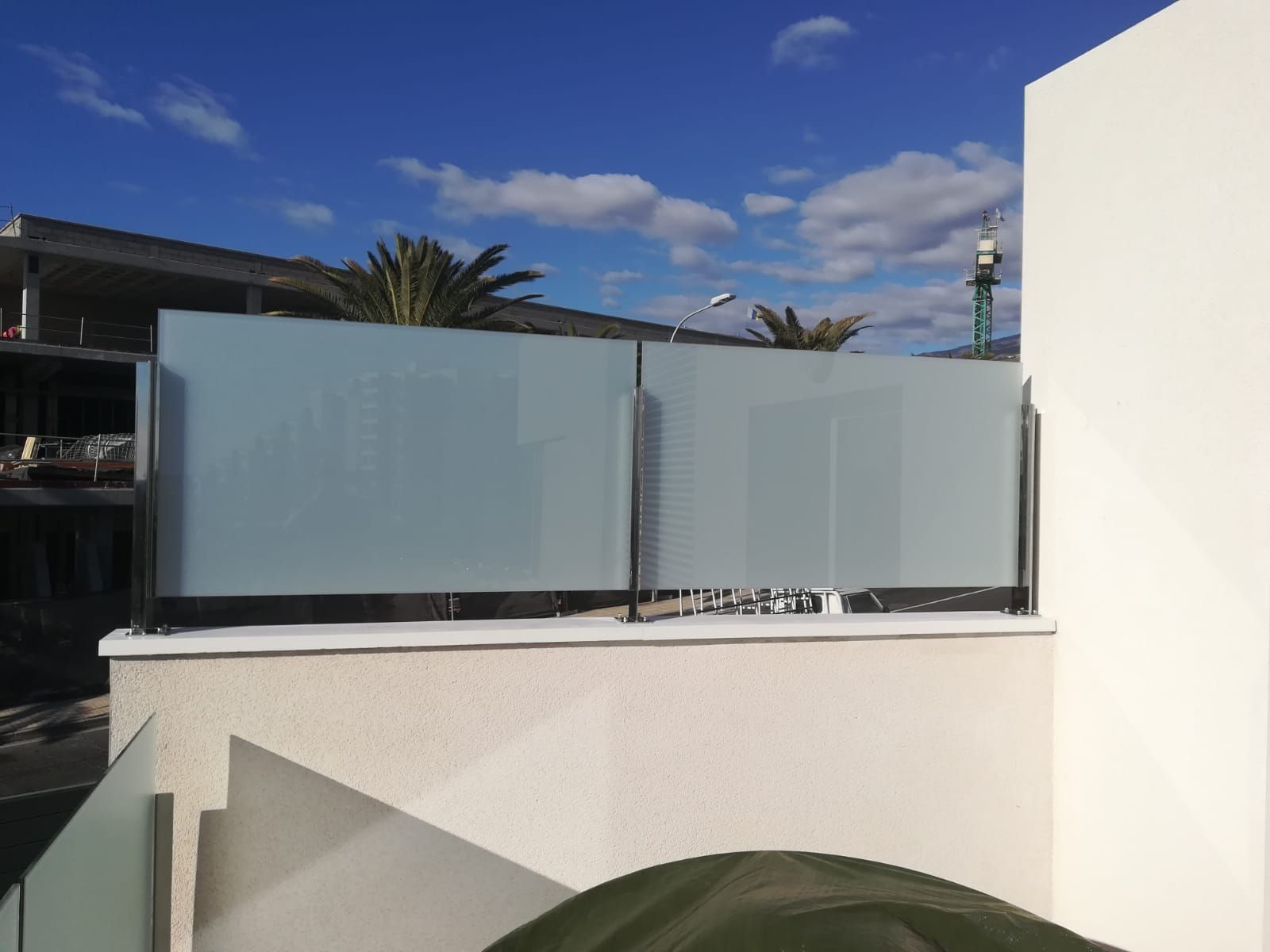 Un edificio blanco con una valla de cristal que lo rodea.