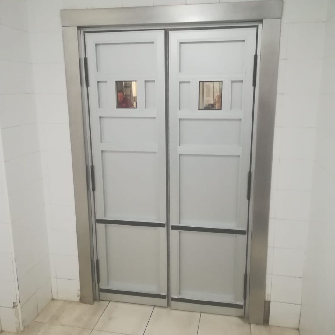 Un par de puertas blancas con marco de acero inoxidable.