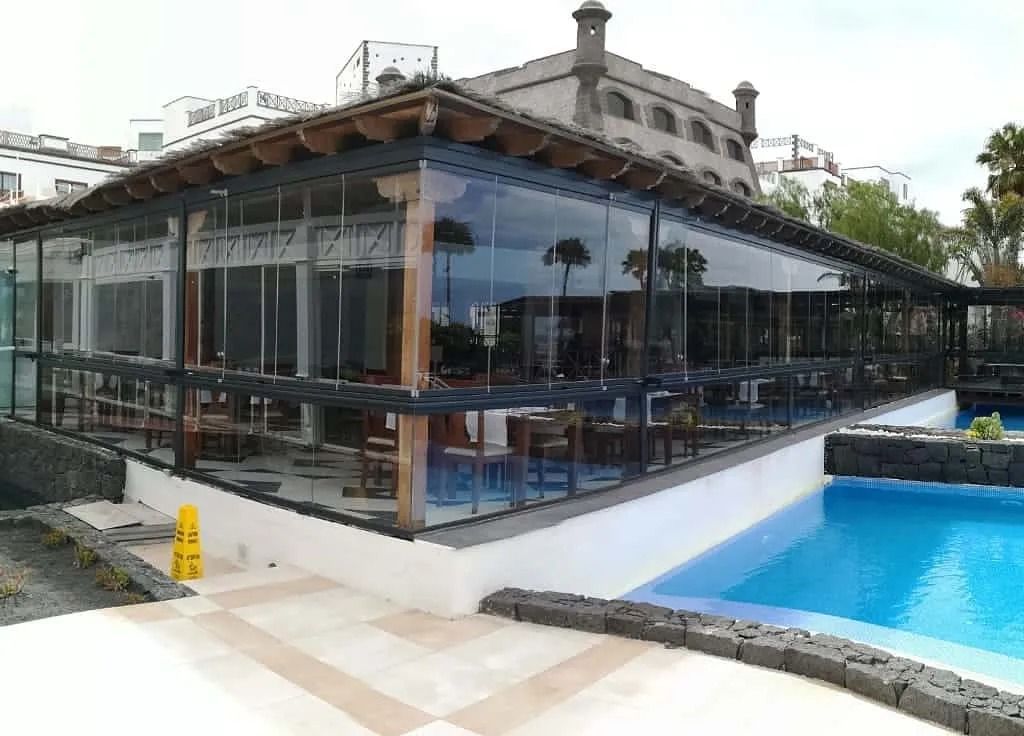 Un gran edificio con una piscina delante.