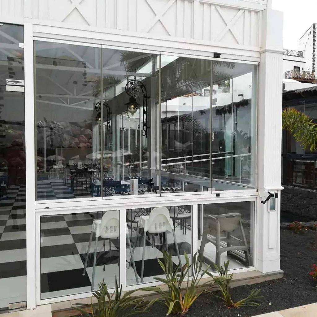 Un restaurante con mesas y sillas frente a un gran ventanal.